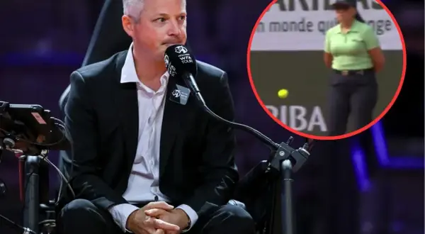 Sędzia na bieżni, w tle kobieta w zielonej koszulce i piłka tenisowa.