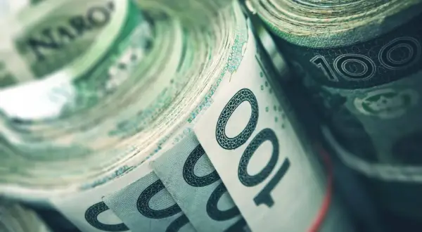 Zwijane banknoty 100 zł, symbolizujące fundusz rezerwy demograficznej, gotowe na przyszłe wyzwania.