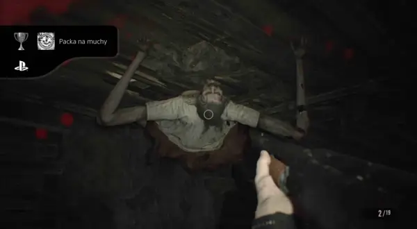 Zdobądź osiągnięcie "Packa na muchy" w Resident Evil 7. Potwór wisi na suficie, a gracz celuje bronią.