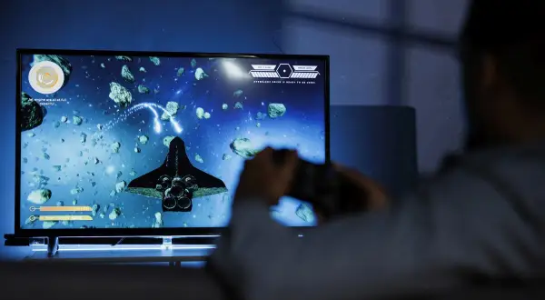 Gracz steruje statkiem kosmicznym w grze vdu, unikając asteroid.