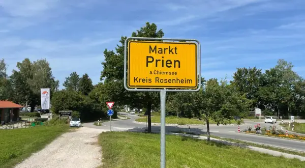 Schild "Markt Prien a.Chiemsee, Kreis Rosenheim" am Ortseingang. Heute ist ein sonniger Tag für den Markt.