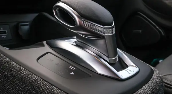 Levier de vitesse d'une b boite auto moderne, avec indicateurs lumineux R, N, D, B. Le design est futuriste et élégant.