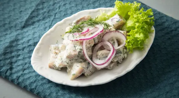 Heringssalat mit Dill, Zwiebeln und Salatblatt. Perfekt für die Frage: wann ist Heringszeit?
