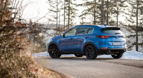 Niebieski Kia Sportage 3 na zimowej drodze. Zastanawiasz się, jakie opony do Kia Sportage 3 będą najlepsze?