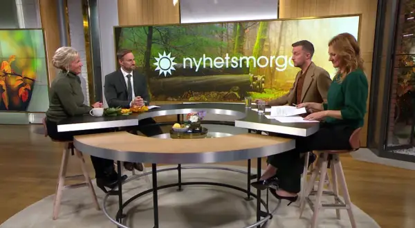 Ulrika Elvgren och kollegor diskuterar nyheter vid ett runt bord.