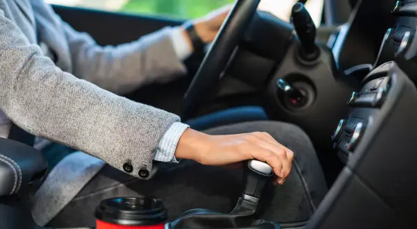 Main d'une personne changeant de vitesse dans une voiture, prêt pour son permis b78.