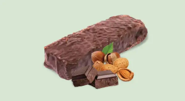 Barretta proteica dopo allenamento, ricoperta di cioccolato, con nocciole, mandorle e pezzi di cioccolato fondente.