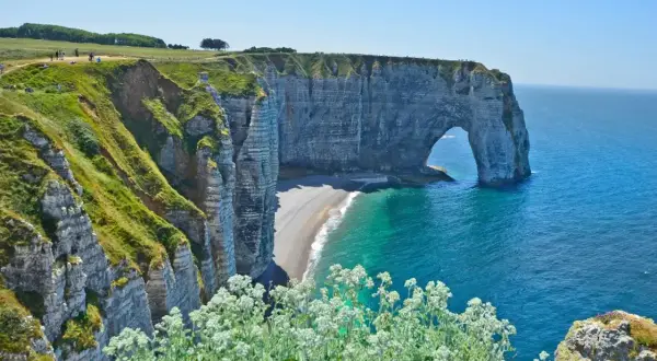 Falaises verdoyantes et arche rocheuse emblématique à Étretat, un paysage normand à couper le souffle, entre Fécamp et le littoral.