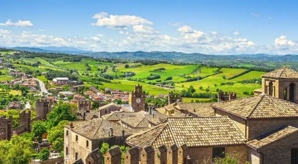Un borgo medievale con torri e tetti in cotto, incastonato tra le verdi colline dell'Emilia Romagna, uno dei 5 borghi più belli della regione.