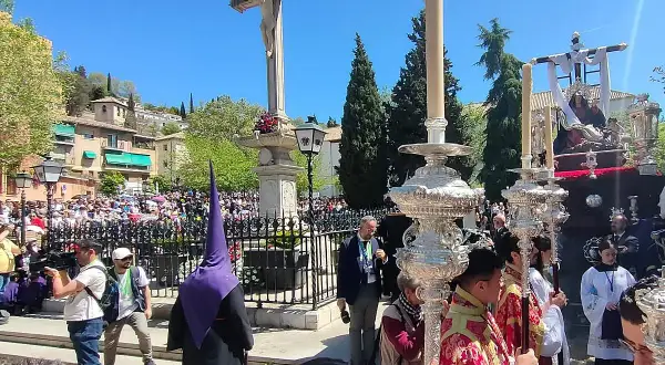 Procesiones Semana Santa Viernes Santo en Granada. Nazarenos con túnicas moradas y pasos procesionales iluminados por velas.