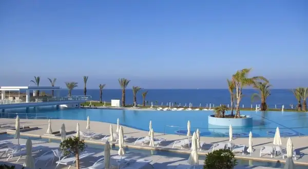 Basen i plaża w King Evelthon Beach Hotel and Resort. Opinie gości potwierdzają piękno tego miejsca.