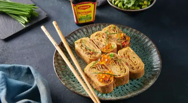 Roladki omlet tamago z ikrą łososia i szczypiorkiem, podane z pałeczkami i sosem Maggi.