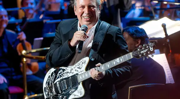Hans Zimmer z gitarą, która brzmi jak ścieżka dźwiękowa do jego filmów. Uśmiechnięty kompozytor na scenie z orkiestrą.