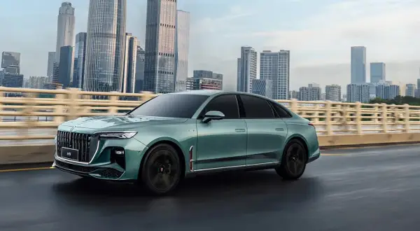 Elegancki, zielony Hongqi H9 na tle drapaczy chmur. Sprawdź, jaka jest jego hongqi h9 cena i poczuj luksus.
