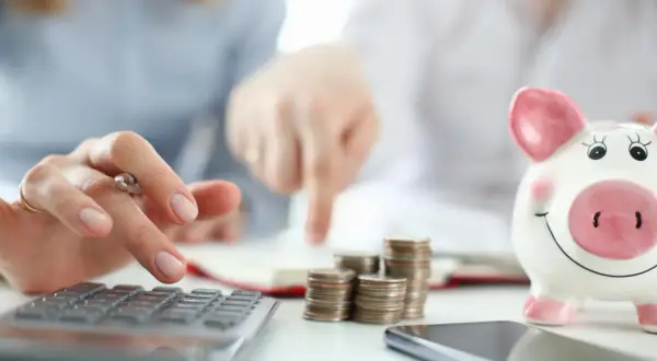 Osoby analizują finanse, liczą monety i patrzą na skarbonkę. Rozważają inwestycje, takie jak obligacje indeksowane inflacją, by chronić oszczędności.