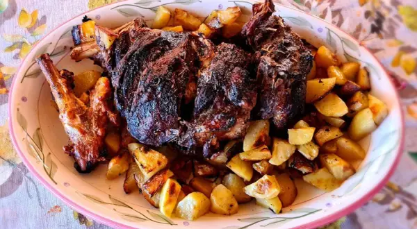 Un succulento agnello al forno con patate dorate, un piatto che profuma di tradizione e festa.