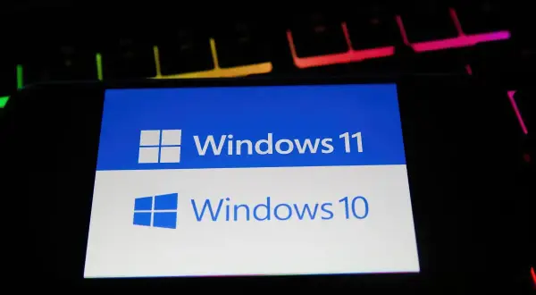 Ekran porównuje Windows 10 i Windows 11, pomagając wybrać najlepszy system Windows 10 czy 11 do gier. Klawiatura RGB w tle dodaje klimatu.