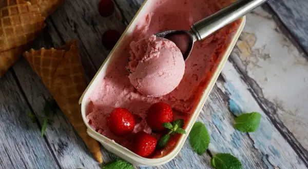 Jak zrobić lody truskawkowe? Pyszne, domowe lody z truskawkami i miętą, gotowe do podania w wafelkach.