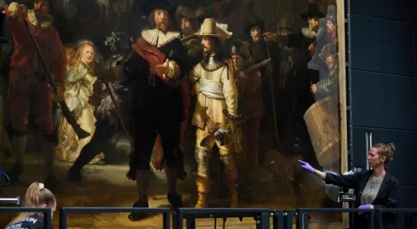 Restauratorin zeigt auf Rembrandts "die nachtwache maler", ein Meisterwerk der Malerei, das gerade untersucht wird.