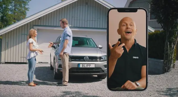 Kvinna och man diskuterar en bil med fel. En man på en mobilskärm ger råd om hur man kan byta in bil med fel.