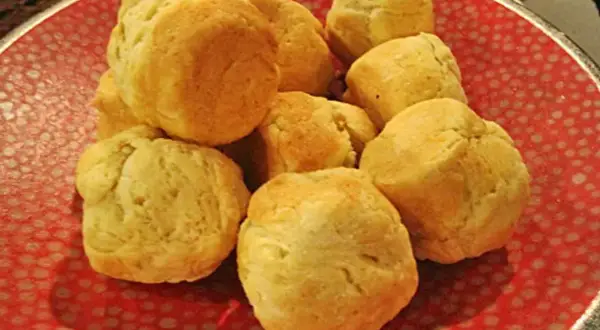 En hög med nybakade scones på en röd tallrik. Perfekt för ett mysigt fika med detta scones recept.