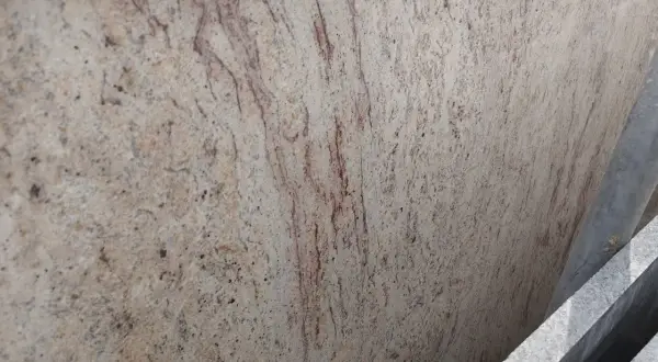 Granit Shivakashi o jasnym, kremowym tle i rudych żyłkach, przypominający starożytne mapy.