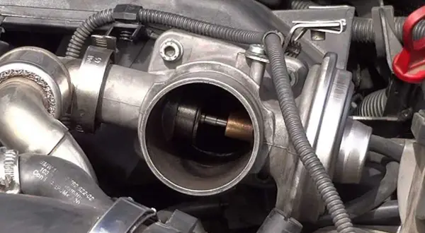 Cuerpo de acelerador de Peugeot, posible causa de DTC 0404. Se observa el mecanismo interno y la válvula.