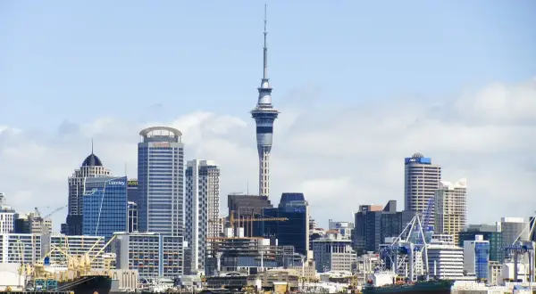 Skyline de Auckland, Nueva Zelanda, con la Sky Tower y barcos en el puerto. ¡Un destino ideal cuando viajar a Nueva Zelanda!