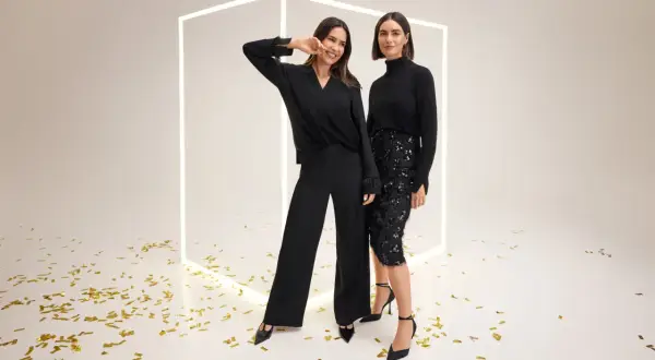 Dwie kobiety w eleganckich czarnych strojach, jedna w spodniach, druga w cekinowej spódnicy. Gerry Weber sukienki i stylizacje na wyjątkowe okazje.