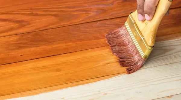 Aplicando barniz a madera de pino sin tratar, transformando su tono natural a un cálido color miel.