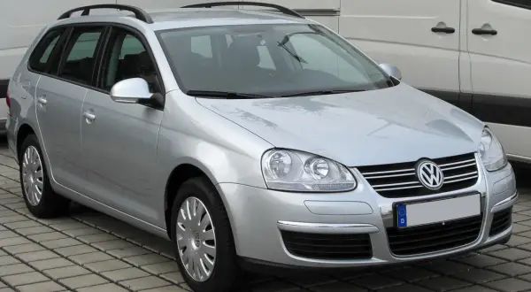 Srebrny Volkswagen Golf 5 Variant z relingami dachowymi, zaparkowany na kostce brukowej.