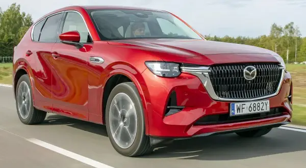 Czerwona Mazda CX-60 na drodze, podczas testu. Kierowca w kabinie.