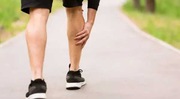 Un corridore si ferma, tenendosi il polpaccio. Potrebbe essere un segnale di un problema ipotonico, che significa una ridotta tonicità muscolare.