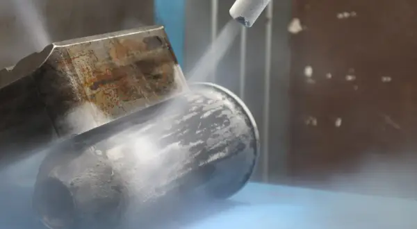 Dysza do czyszczenia suchym lodem strumieniuje na metalowy element, tworząc mgłę.