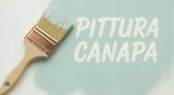 Pennello con calce a pennello che crea la scritta "PITTURA CANAPA" su una superficie chiara.