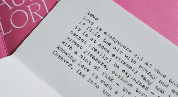 Piękny wiersz o miłości i tęsknocie, z tekstem "love is everywhere" na białej kartce, obok różowej okładki z napisem "AUDRE LORDE".