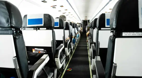 Blick in die Kabine eines Flugzeugs. Die Sitze sind in Reihen angeordnet. Die Frage, wo man im Flugzeug am besten sitzt, bleibt offen.