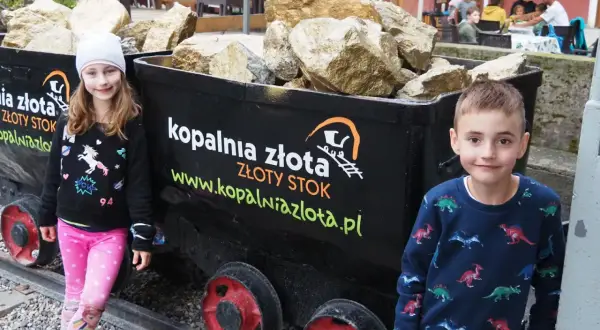 Dzieci przy wagonikach z "złotem" w Kopalni Złota w Złotym Stoku. Atrakcje dla całej rodziny.
