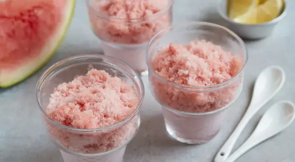 Erfrischendes Wassermelonen-Shave-Ice-Rezept in Gläsern, garniert mit Zitronenspalten und Wassermelone. Perfekt für heiße Tage!