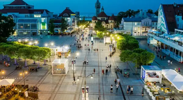 Wieczorny spacer po sopockim deptaku, gdzie tętni życiem **Sopot stare miasto**. Ludzie przechadzają się wśród iluminacji, tworząc niepowtarzalny klimat.