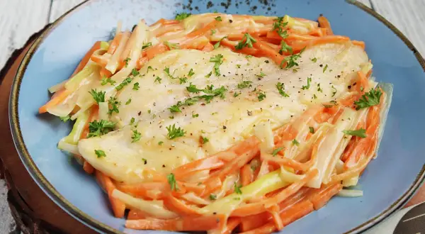 Ein zartes Rotbarschfilet mit einer cremigen Senfsauce, umgeben von julienniertem Gemüse.