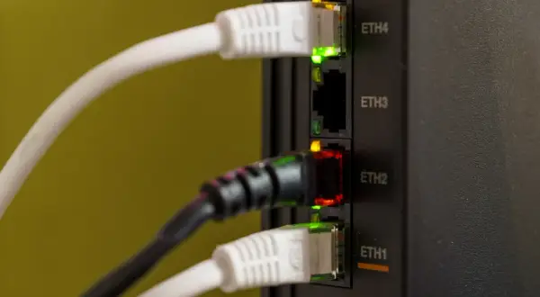 Wtyczki Ethernet w routerze. Zielone i czerwone diody sygnalizują połączenie. Jak sprawdzić czy jest światłowód w bloku? Sprawdź diody na routerze.
