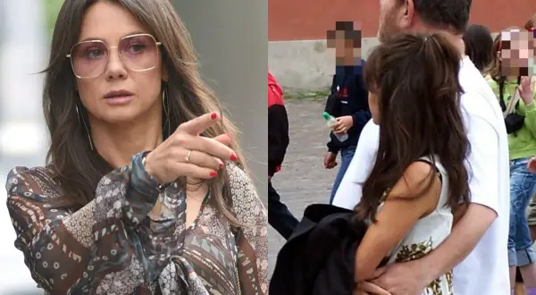 Kobieta w okularach i wzorzystej bluzce wskazuje palcem, obok mężczyzna obejmuje kobietę.