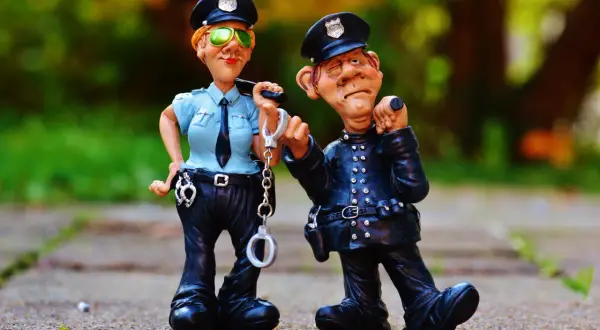 Dwie figurki policjantów, jeden z kajdankami, drugi z miną sugerującą, że trzeźwy poranek to podstawa prawna.