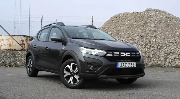 En mörkgrå Dacia Sandero Stepway står parkerad utomhus. Bilen är redo för ett däcktest.