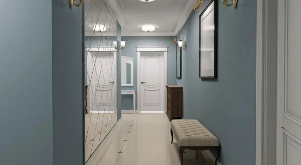 Długi wąski przedpokój inspiracje: lustrzana ściana, ławka, komoda i eleganckie oświetlenie tworzą przytulną przestrzeń.