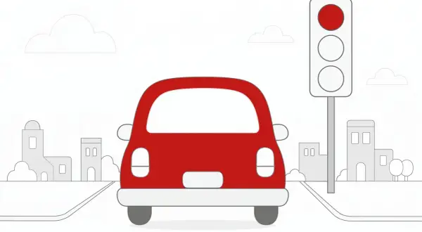 Czerwony samochód zatrzymał się przed sygnalizatorem świetlnym. Czekając na zielone, kierowca obserwuje miejski krajobraz. Wjazd na czerwonym świetle to niebezpieczne wykroczenie.