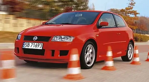 Czerwony Fiat Stilo 1.9 JTD manewruje między pachołkami na torze.