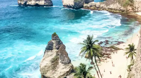 Rajska plaża z palmami i turkusową wodą. Marzysz o podróży? Sprawdź, ile trwa lot na Bali!