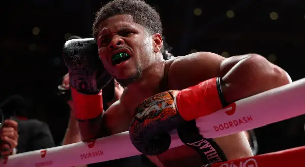 Boxer with green mouthguard grimaces, ready to deliver a powerful counter jab.